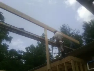 Carpenter setting a ridge beam over a new addition frame — Ice Dam Removal by Roofing Brothers in Aptos